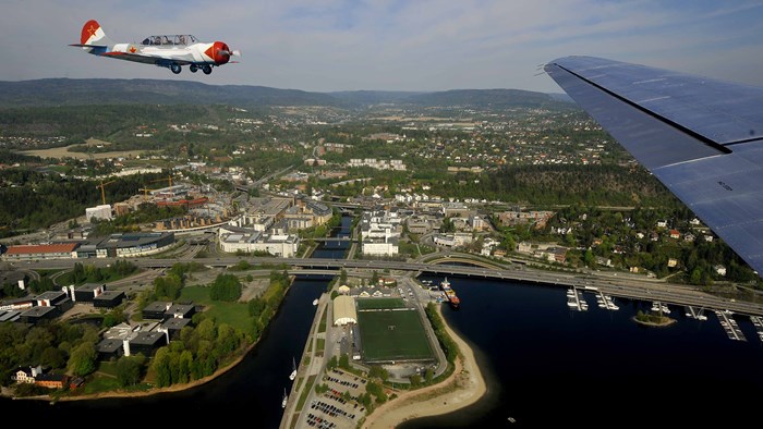 Flyfoto over Sandvika med fly i bakgrunnen